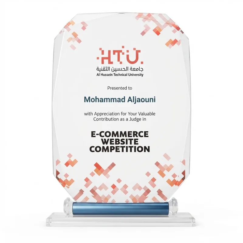 Clear acrylic award on a blue and glass base, presented by Al Hussein Technical University to Mohammad Aljaouni for his contribution as a judge in the E-Commerce Website Competition.